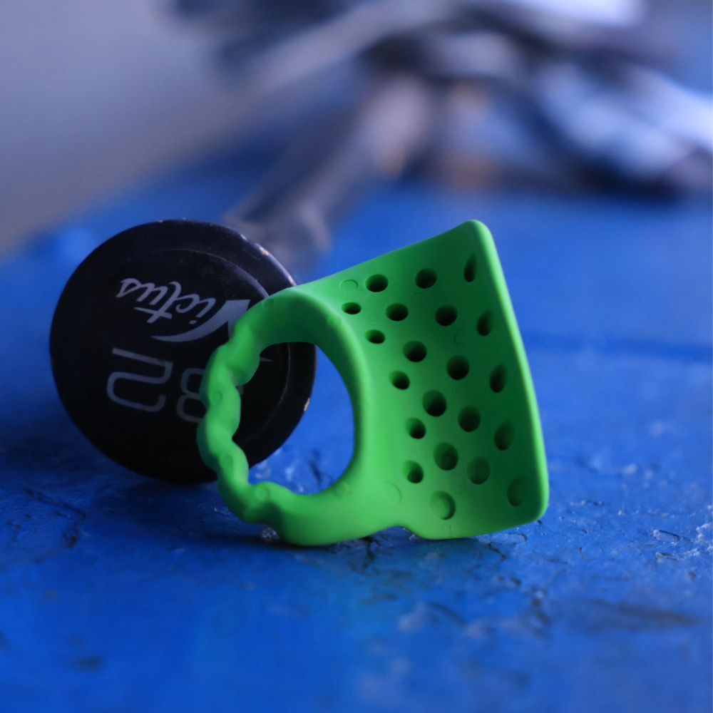 Launchpad thumb guard channel cutouts compressing against a bat knob to absorb bat sting